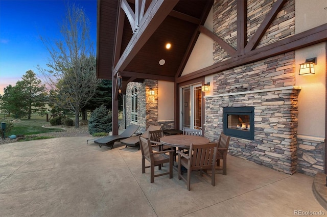 patio terrace at dusk with an outdoor stone fireplace