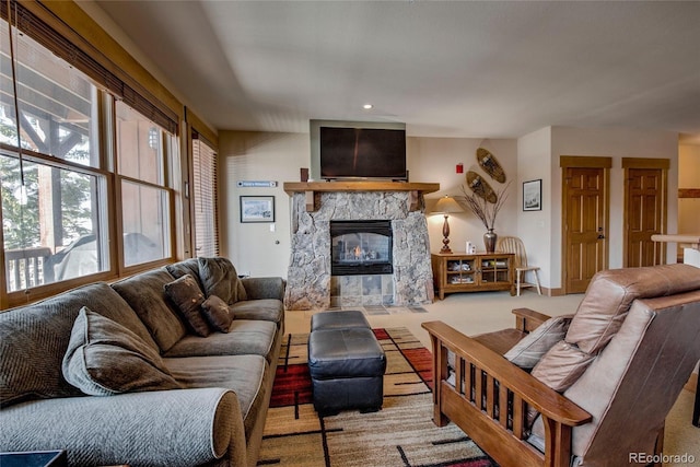 carpeted living room featuring a stone fireplace