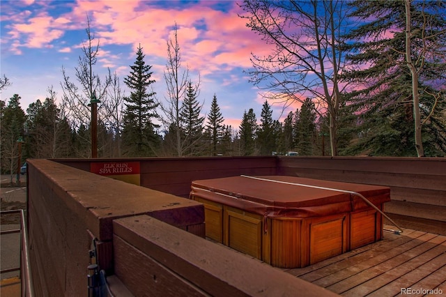 deck at dusk with a hot tub