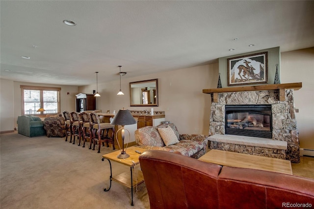 living room with sink, a stone fireplace, light colored carpet, and a textured ceiling