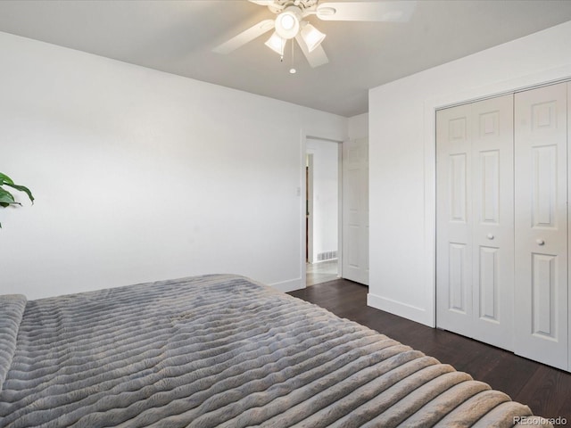 bedroom featuring a closet, dark wood-type flooring, and ceiling fan