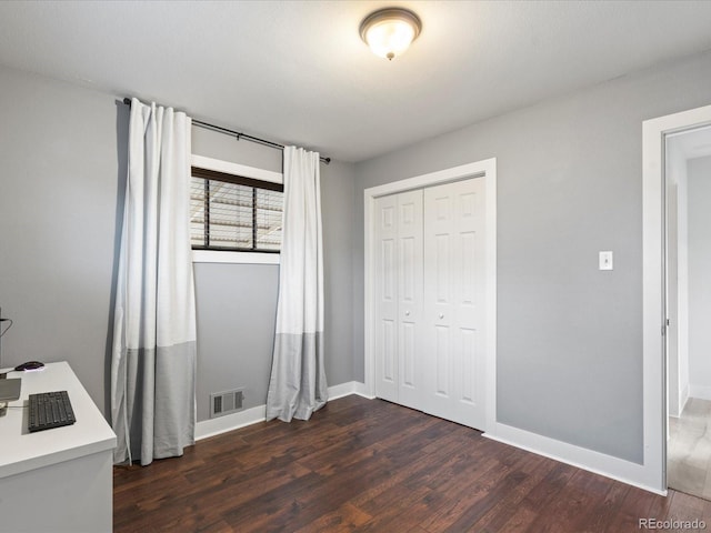 unfurnished bedroom with dark hardwood / wood-style flooring and a closet