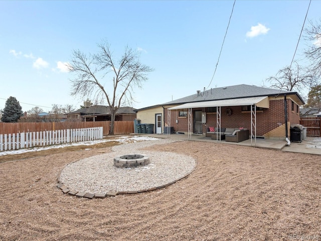 rear view of house with a patio area and an outdoor living space with a fire pit