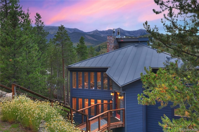 property exterior at dusk featuring a mountain view