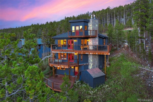 back house at dusk featuring a balcony