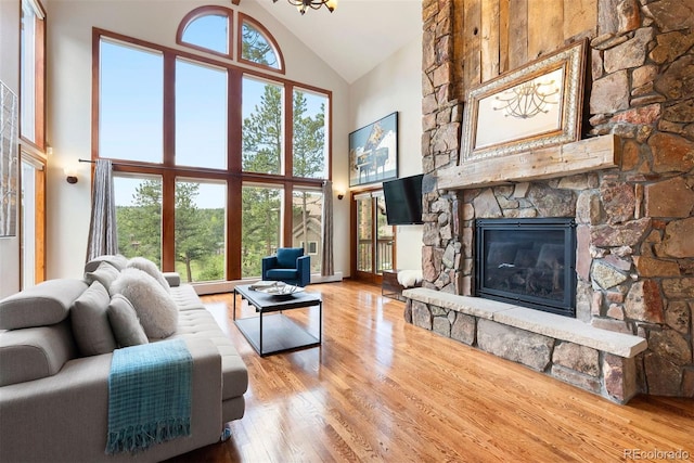 2122 Cramner Ct, Evergreen, CO 80439 - living area featuring high vaulted ceiling, a fireplace, wood finished floors, and plenty of natural light