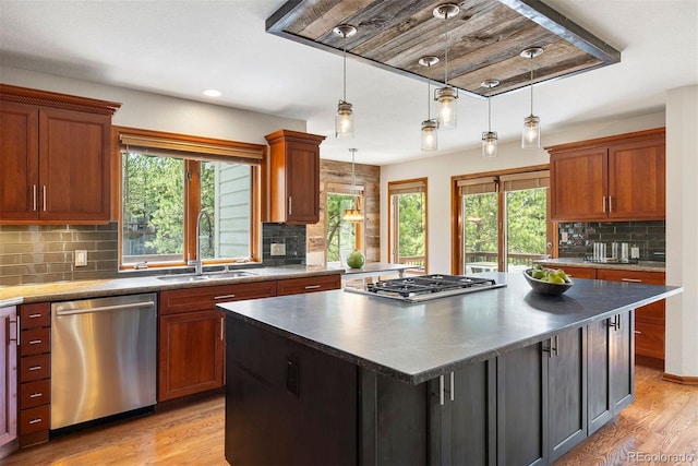 2122 Cramner Ct, Evergreen, CO 80439 - kitchen with stainless steel appliances, a sink, light wood-type flooring, backsplash, and a center island