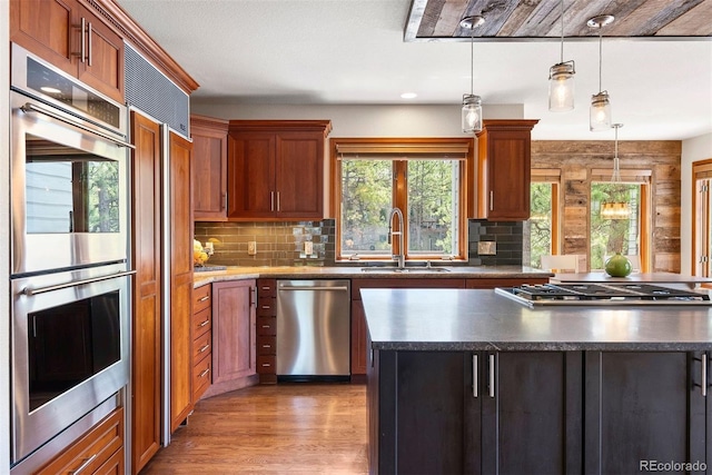 2122 Cramner Ct, Evergreen, CO 80439 - kitchen featuring stainless steel appliances, a sink, decorative backsplash, dark countertops, and light wood finished floors