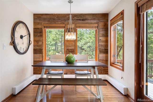 2122 Cramner Ct, Evergreen, CO 80439 - dining space featuring baseboards, light wood-type flooring, a chandelier, and wooden walls