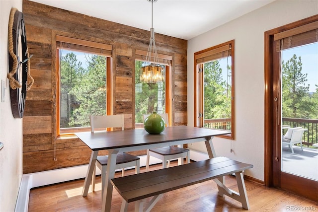 2122 Cramner Ct, Evergreen, CO 80439 - dining space with a chandelier, light wood finished floors, wooden walls, and baseboards