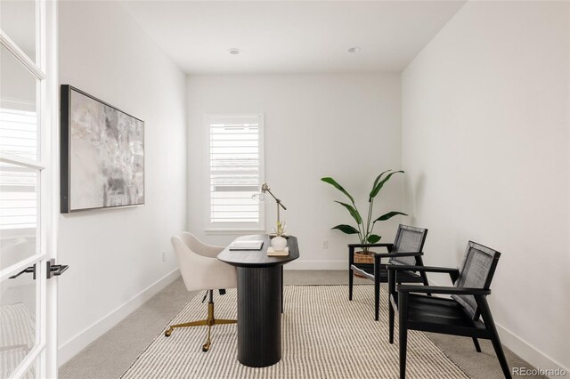 carpeted office space featuring baseboards