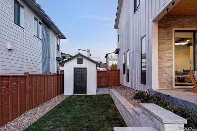 view of yard featuring an outbuilding, fence, and a shed