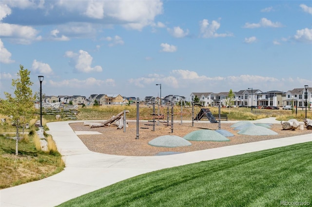 view of home's community featuring playground community, a lawn, and a residential view