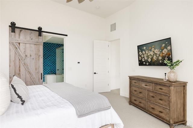 bedroom with light carpet, a barn door, visible vents, and ceiling fan