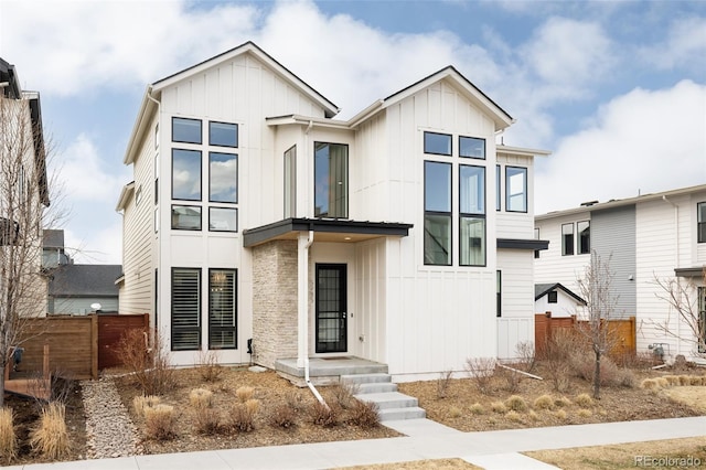 modern farmhouse style home with board and batten siding and fence