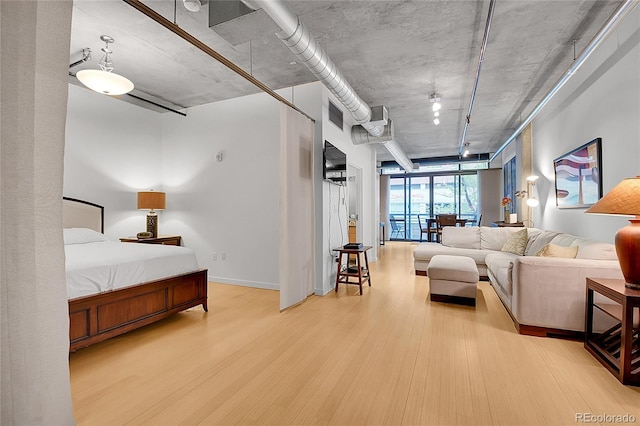 bedroom featuring visible vents, baseboards, and wood finished floors