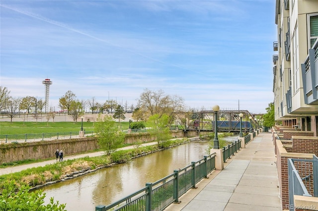 view of home's community with fence and a water view