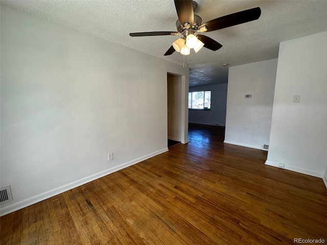 empty room with ceiling fan, a textured ceiling, and dark wood-type flooring