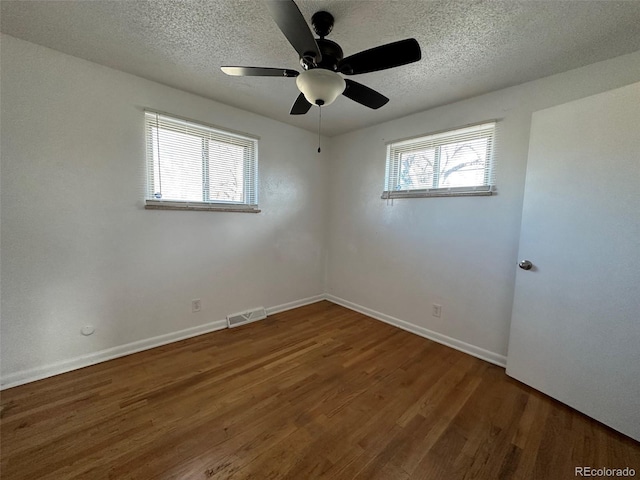 unfurnished room with ceiling fan, a textured ceiling, and dark hardwood / wood-style floors