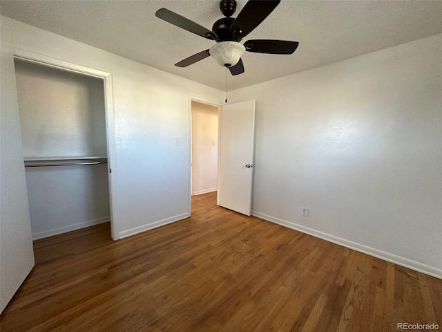 unfurnished bedroom featuring dark hardwood / wood-style flooring, ceiling fan, and a closet