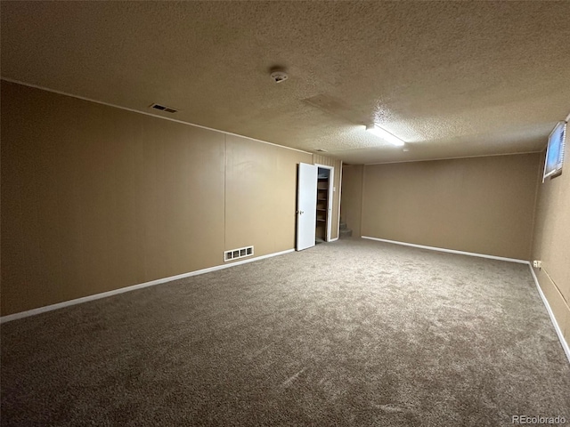 spare room featuring carpet and a textured ceiling