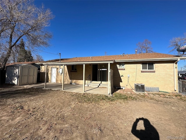 rear view of house with a storage unit and a patio area