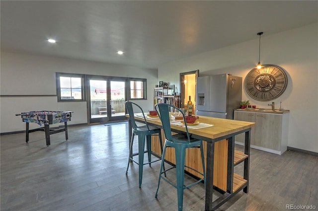 kitchen with recessed lighting, dark wood finished floors, stainless steel fridge with ice dispenser, a sink, and baseboards