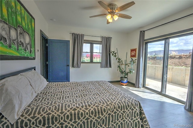 bedroom featuring wood finished floors, access to outside, ceiling fan, and multiple windows