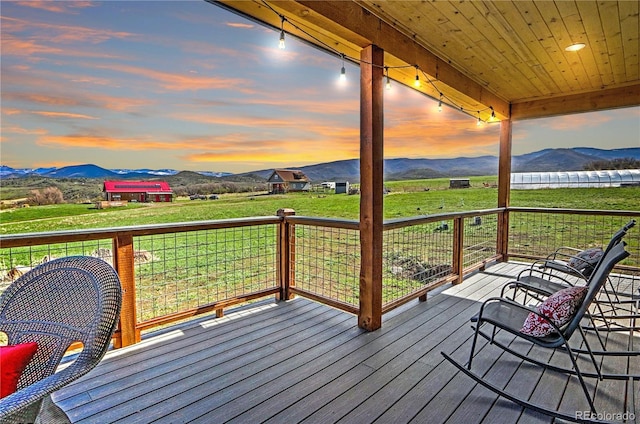 deck at dusk featuring a mountain view
