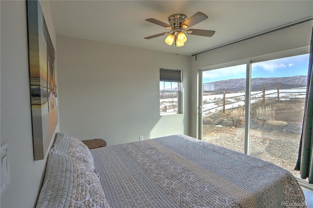 bedroom with a ceiling fan and a mountain view