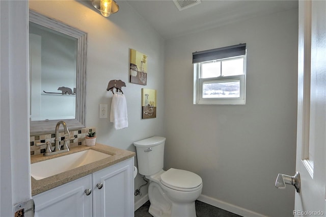 bathroom featuring tasteful backsplash, vanity, baseboards, toilet, and visible vents