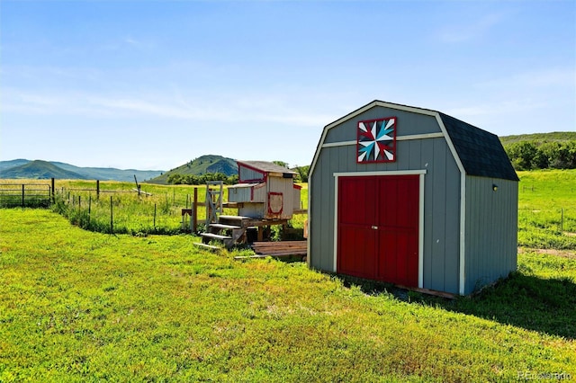 view of shed featuring fence, a rural view, and a mountain view