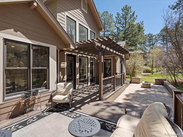 wooden deck with a pergola, a fire pit, and a patio area