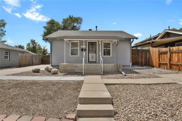 bungalow featuring a porch and fence