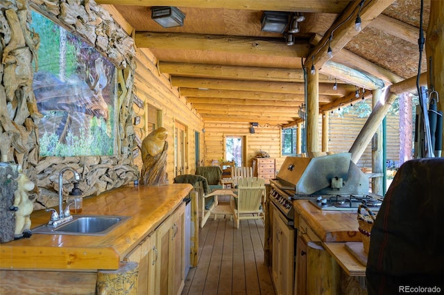 115 Lions Gate Dr, Winter Park, CO 80482 - kitchen with a sink, log walls, wood counters, and dark wood-type flooring