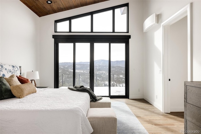 bedroom featuring access to exterior, high vaulted ceiling, light wood-type flooring, a mountain view, and wooden ceiling