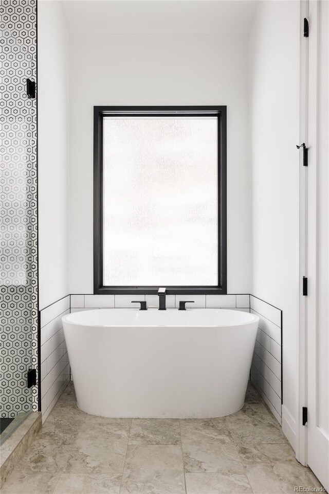 bathroom with a tub and plenty of natural light