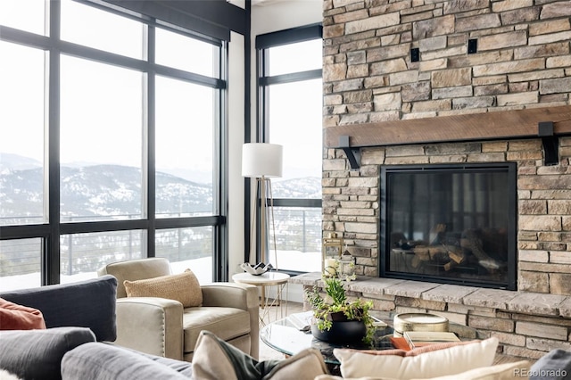 living room featuring a mountain view and a stone fireplace