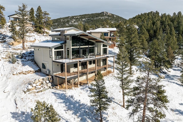 snow covered house with a balcony and a mountain view