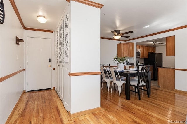 dining area with light hardwood / wood-style flooring, ceiling fan, and crown molding