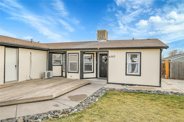 doorway to property with ac unit, a yard, and a wooden deck