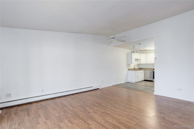unfurnished living room with a baseboard radiator, ceiling fan, a sink, light wood-style floors, and baseboards
