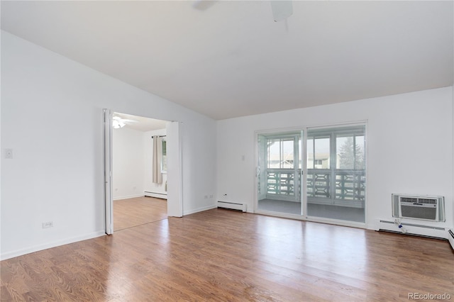 unfurnished room with ceiling fan, a baseboard heating unit, wood finished floors, lofted ceiling, and a wall mounted AC