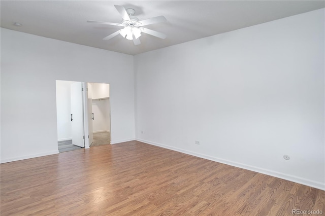 unfurnished room with wood finished floors, ceiling fan, and baseboards