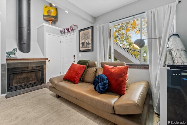 living room featuring a tiled fireplace and hardwood / wood-style floors