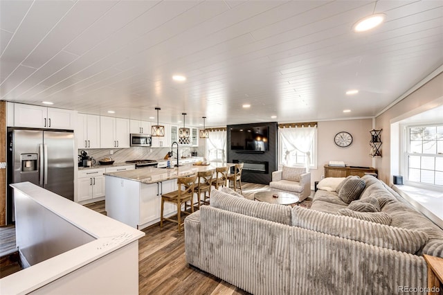 living room with recessed lighting, a glass covered fireplace, and dark wood-style floors