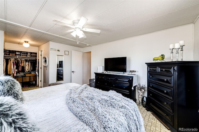 bedroom with a walk in closet and a ceiling fan