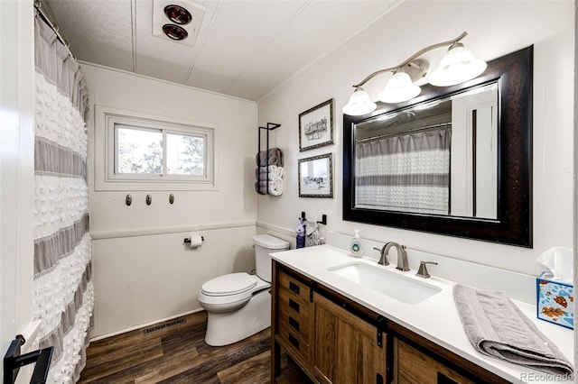 bathroom featuring visible vents, toilet, a shower with curtain, wood finished floors, and vanity