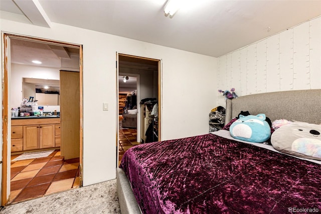 bedroom with light colored carpet and ensuite bathroom