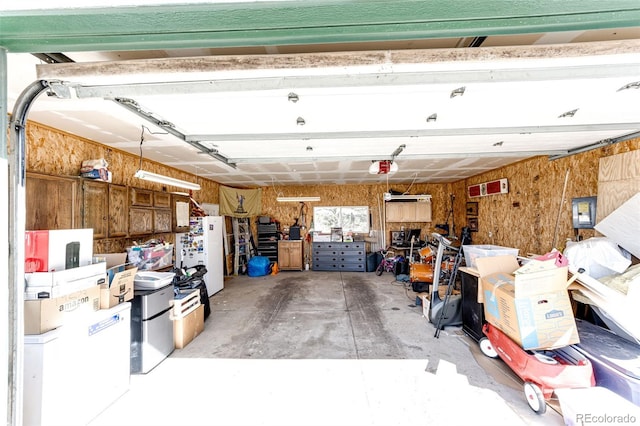 garage with freestanding refrigerator and a garage door opener